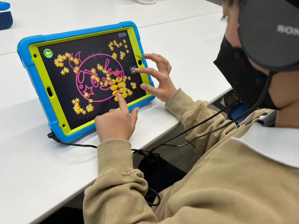 姫路駅南・オンラインのそろタッチ教室|ワンダーランド 3 ヘッドホンをつけ、タブレットのそろタッチに取り組む子ども