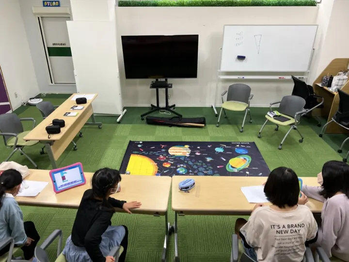 姫路の子ども向けSTEAM|英語で学ぶものづくり|ワンダーランド 9 STEAM教材とタブレットを囲んで活動する子どもたち