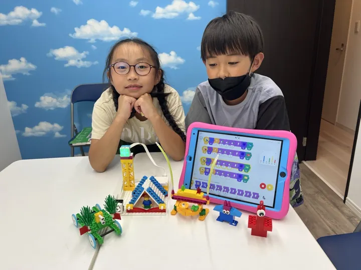 姫路の子ども向けSTEAM|英語で学ぶものづくり|ワンダーランド 10 ブロックで作った作品とタブレットを紹介する子どもたち